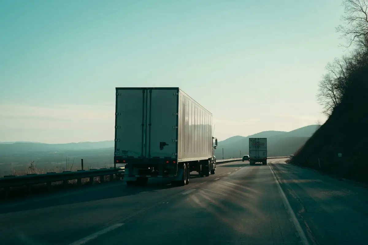 Freight trucks on an open highway at sunset